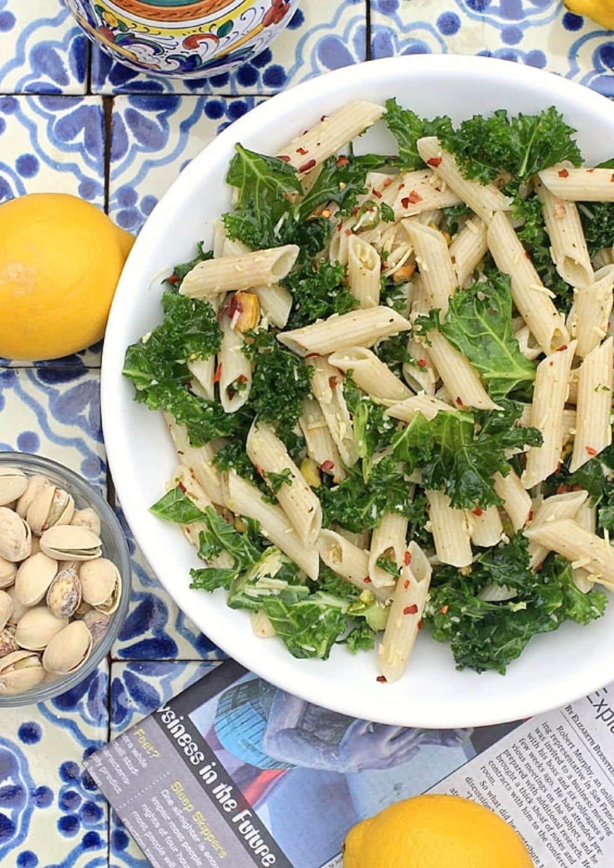 Lemony Kale Pasta Salad with Pistachio Nuts on a white plate.