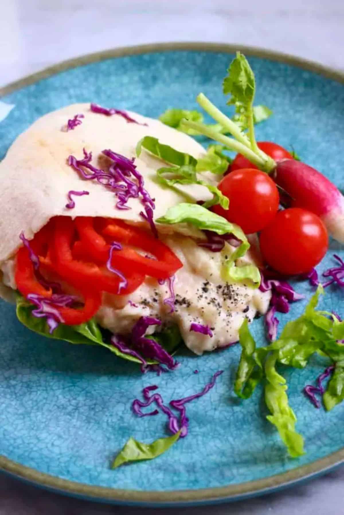 White Bean Sandwich with veggies on a blue plate.