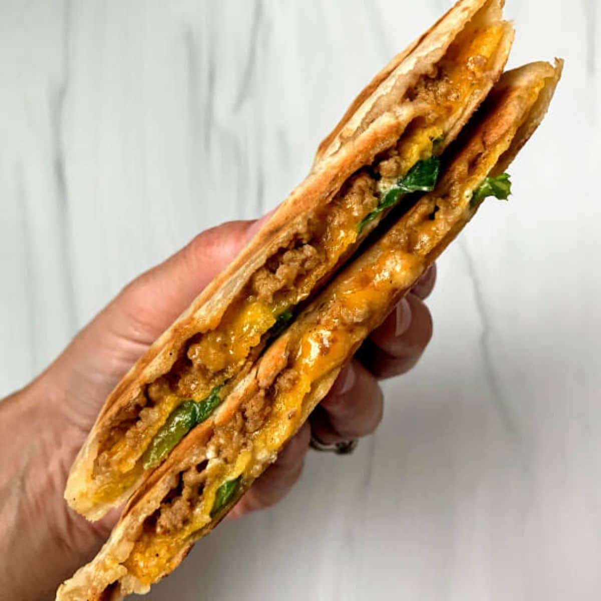 Gluten-Free Crunchwrap Supreme held by hand.