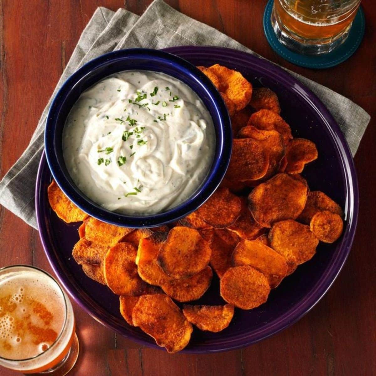 Cilantro Dip in a blue bowl on a purple tray with chips.