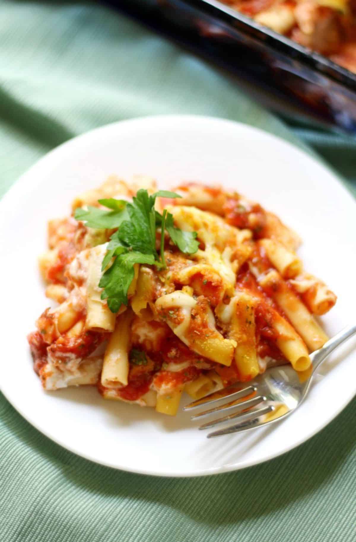 Mom's Best Classic Gluten-Free Vegan Baked Ziti on a white plate with a fork.