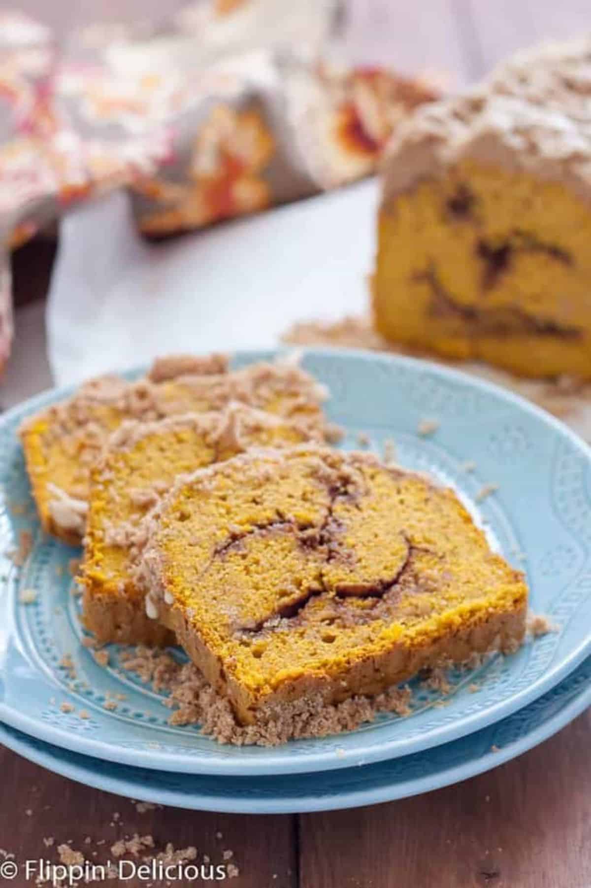 Three slices of Gluten-free Pumpkin Cinnamon Swirl Quick Bread on a blue plate.