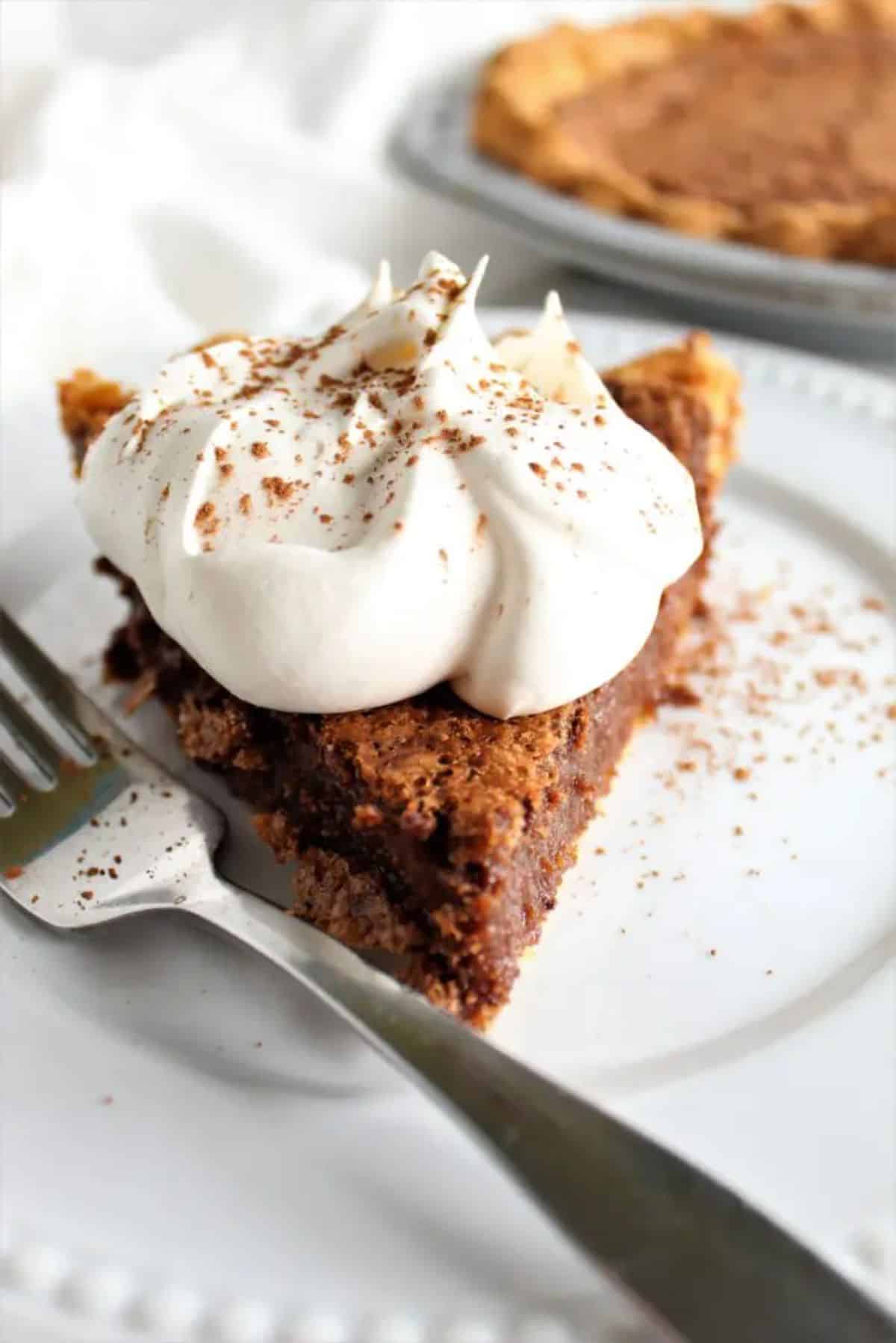 A piece of Gluten-Free Chocolate Chess Pie on a white plate with a fork.