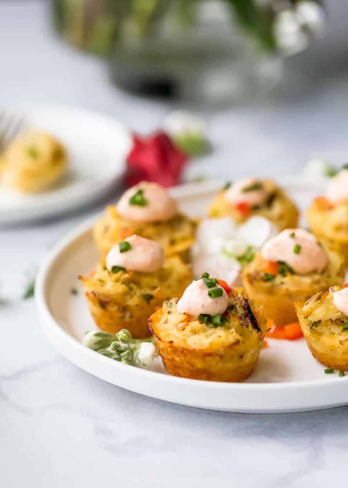 Mini Crab Cakes With Sriracha Sauce on a white tray.