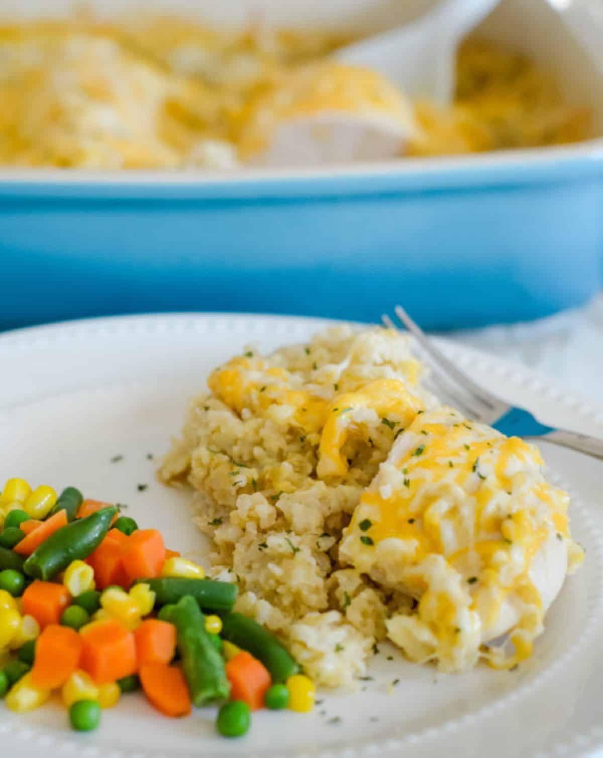 Gluten-Free Cheesy Chicken and Rice on a white plate with a fork.