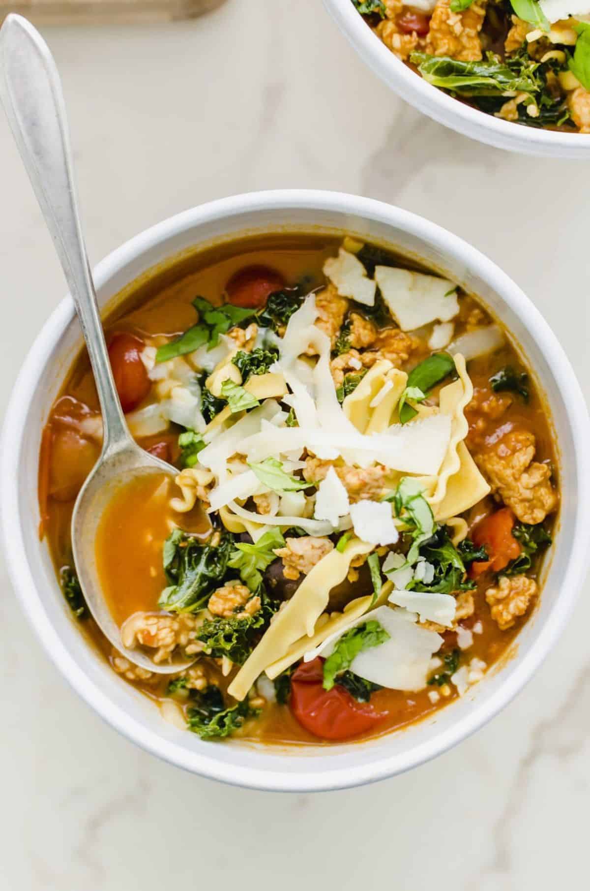 Easy Lasagna Soup in a white bowl with a spoon.