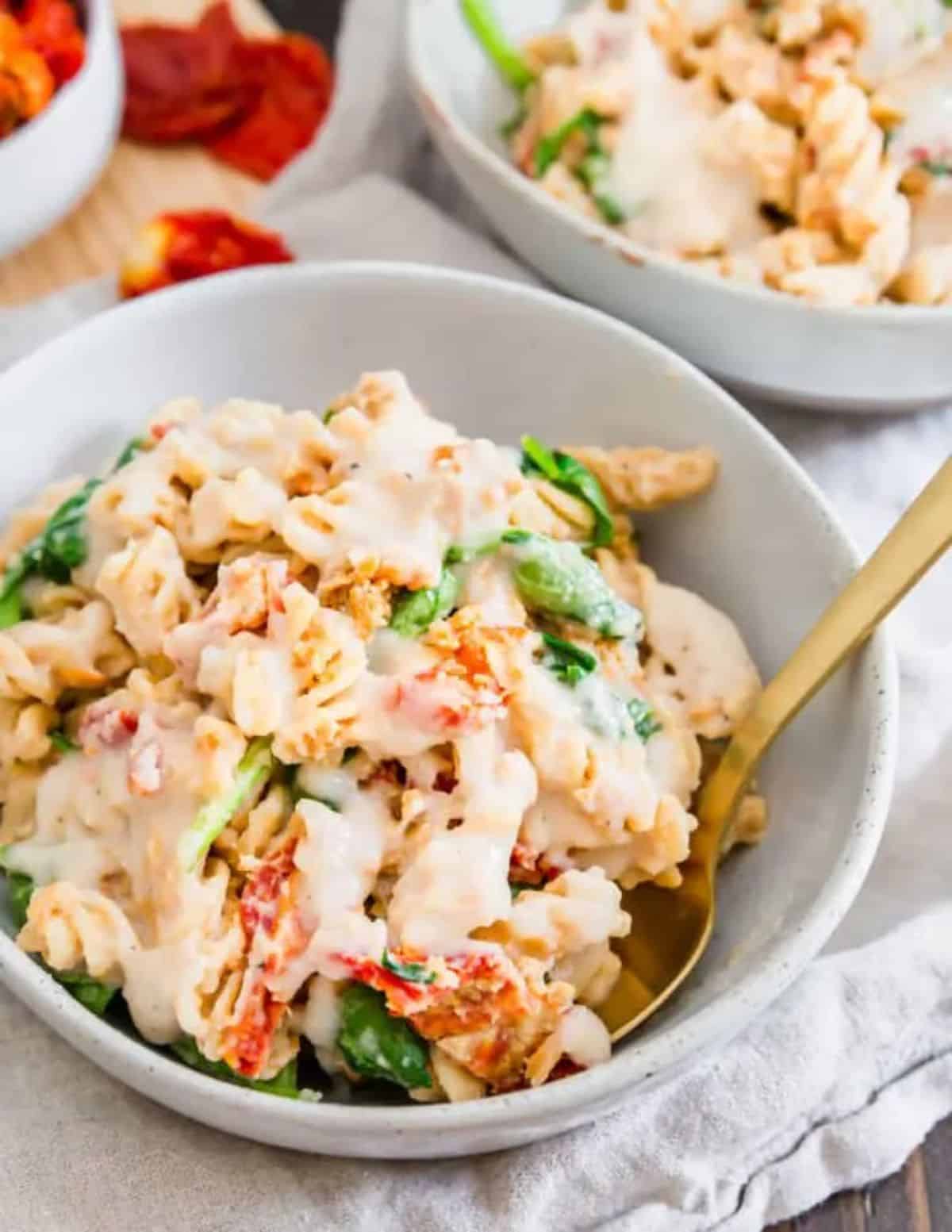 Creamy White Bean Pasta in a white bowl with a spoon.