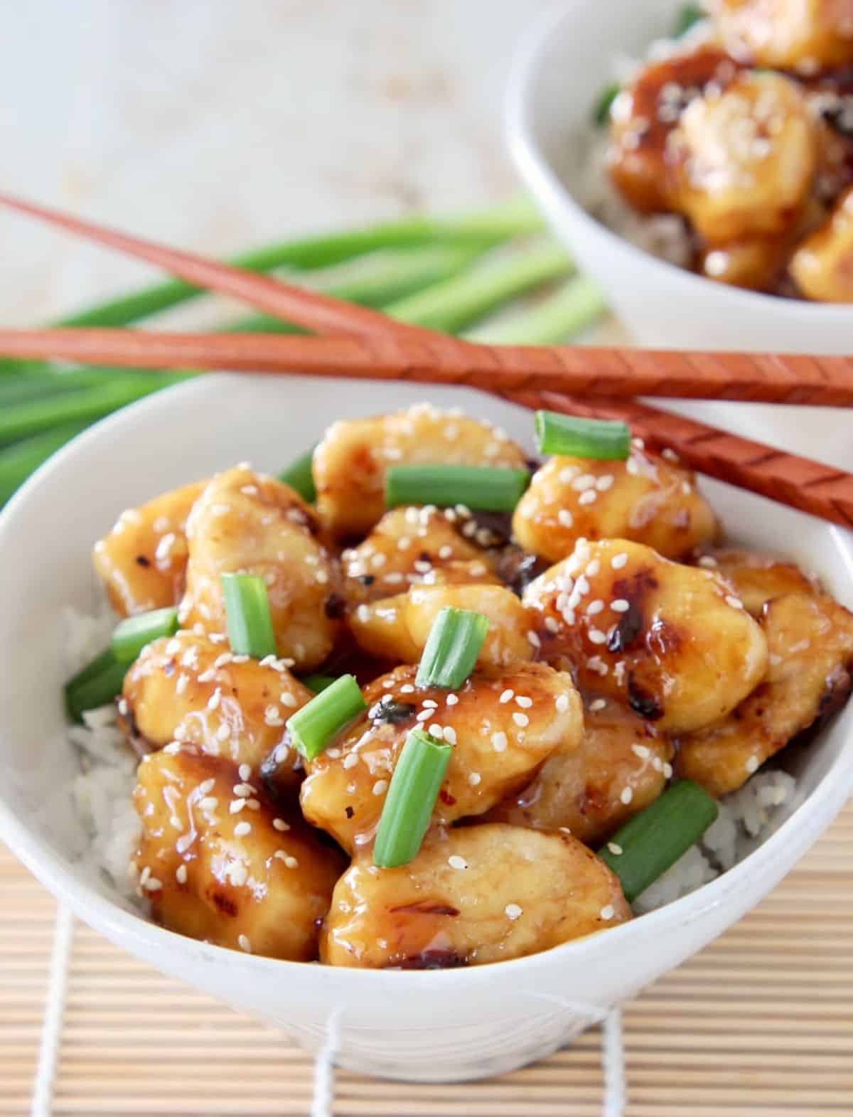 Gluten-Free Chinese Honey Chicken in a white bowl with chopsticks.