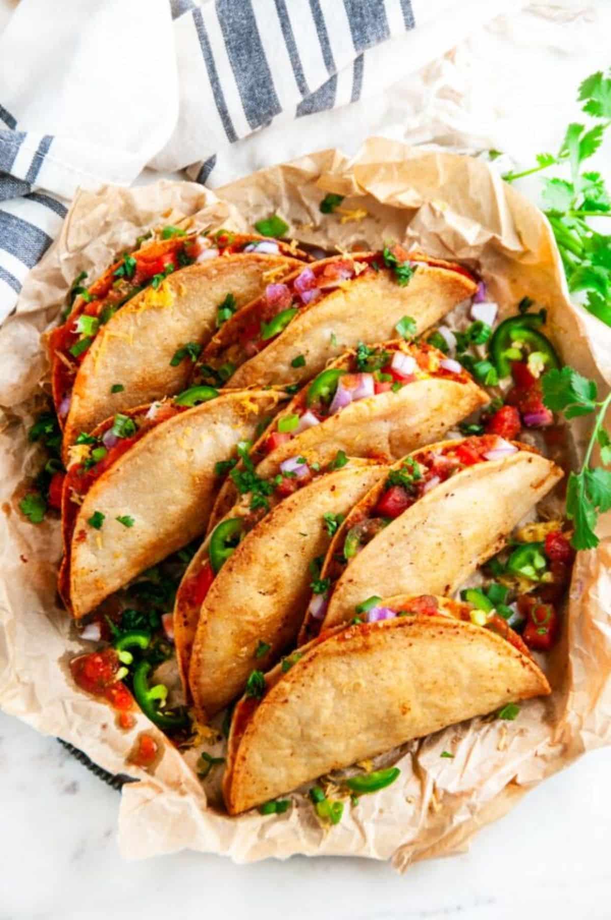 Cheesy Potato Tacos (Tacos de Papa) on a piece of brown paper.