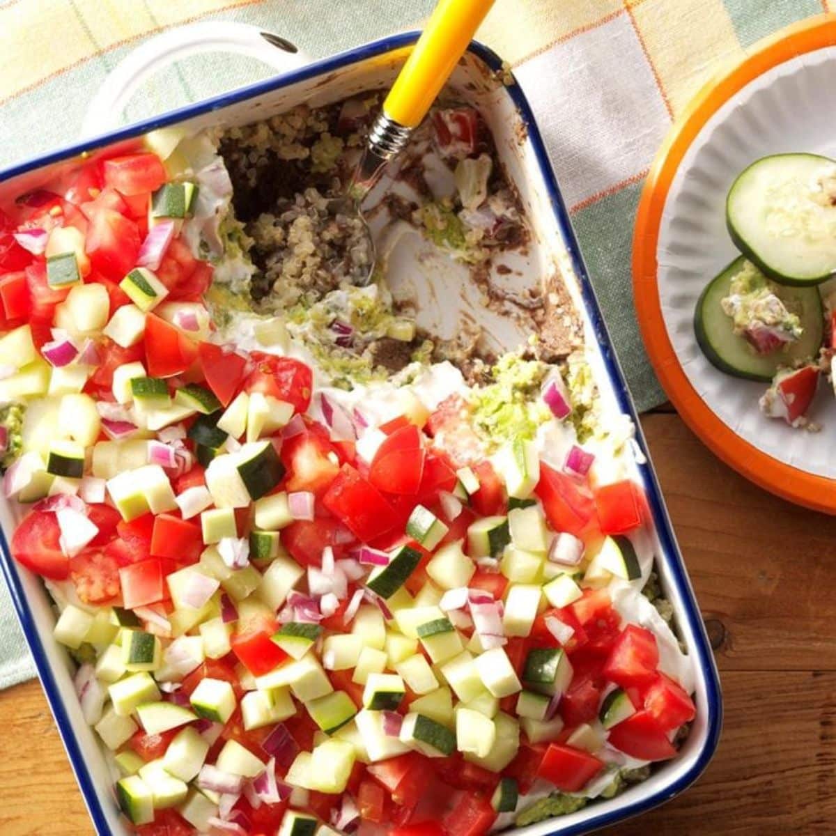 Skinny Quinoa Veggie Dip in a casserole with a spoon.