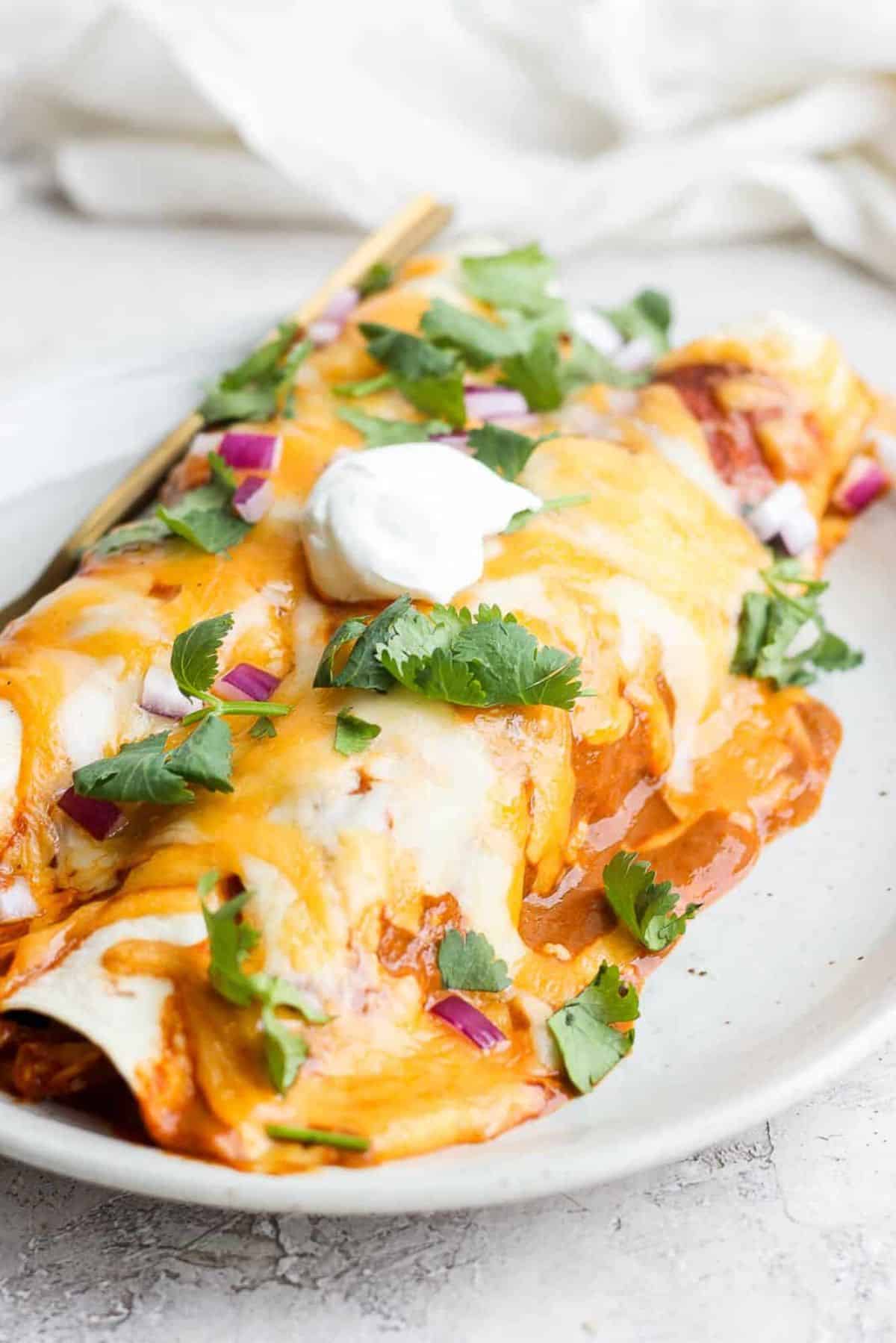 Healthy Gluten-Free Chicken Enchiladas on a white tray.