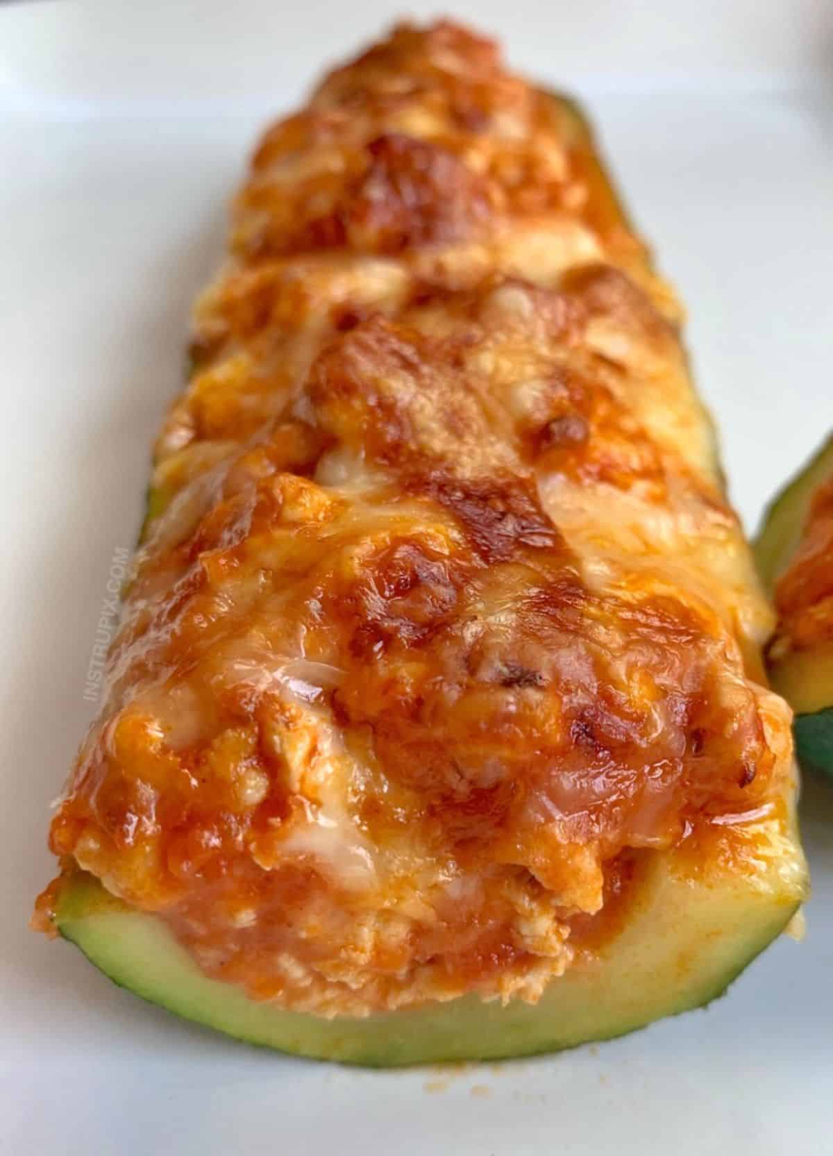 Keto Chicken Parmesan Zucchini Boat on a white plate.