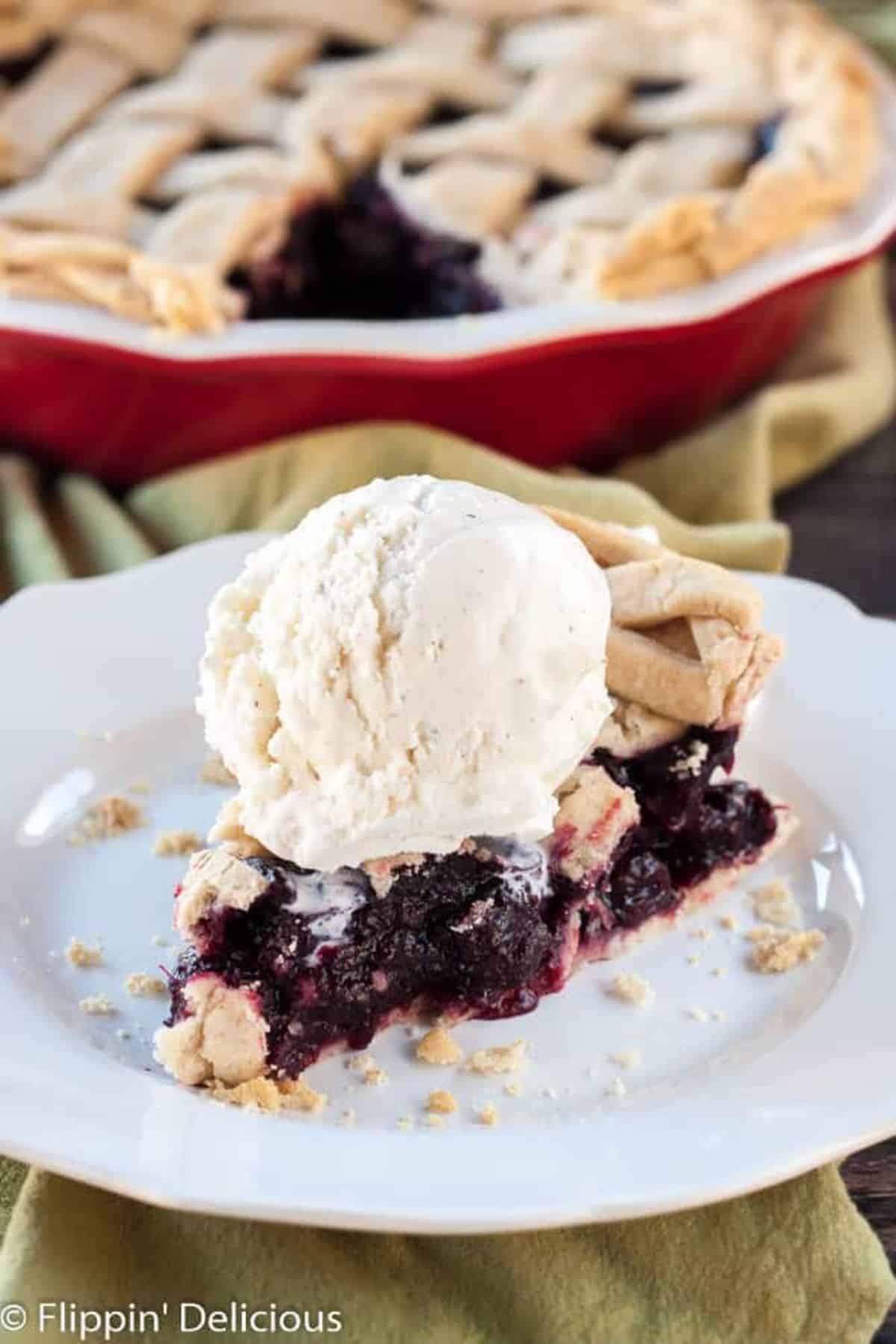 A piece of Gluten-Free Dark Cherry Pie with Lemon Zest on a white plate.