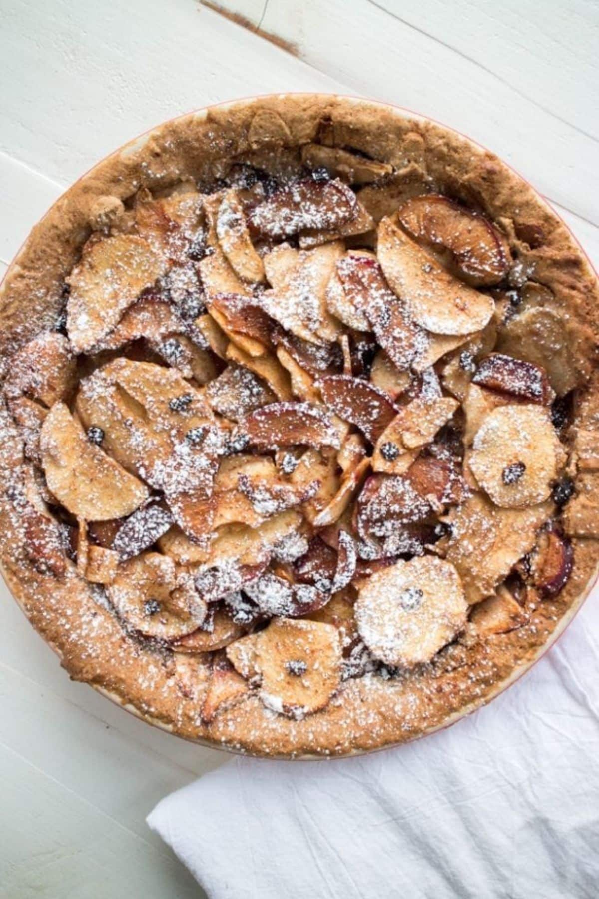 Gluten Free Sugar​ ​Plum​ ​Apple​ ​Currant​ ​Pie on a wooden table.