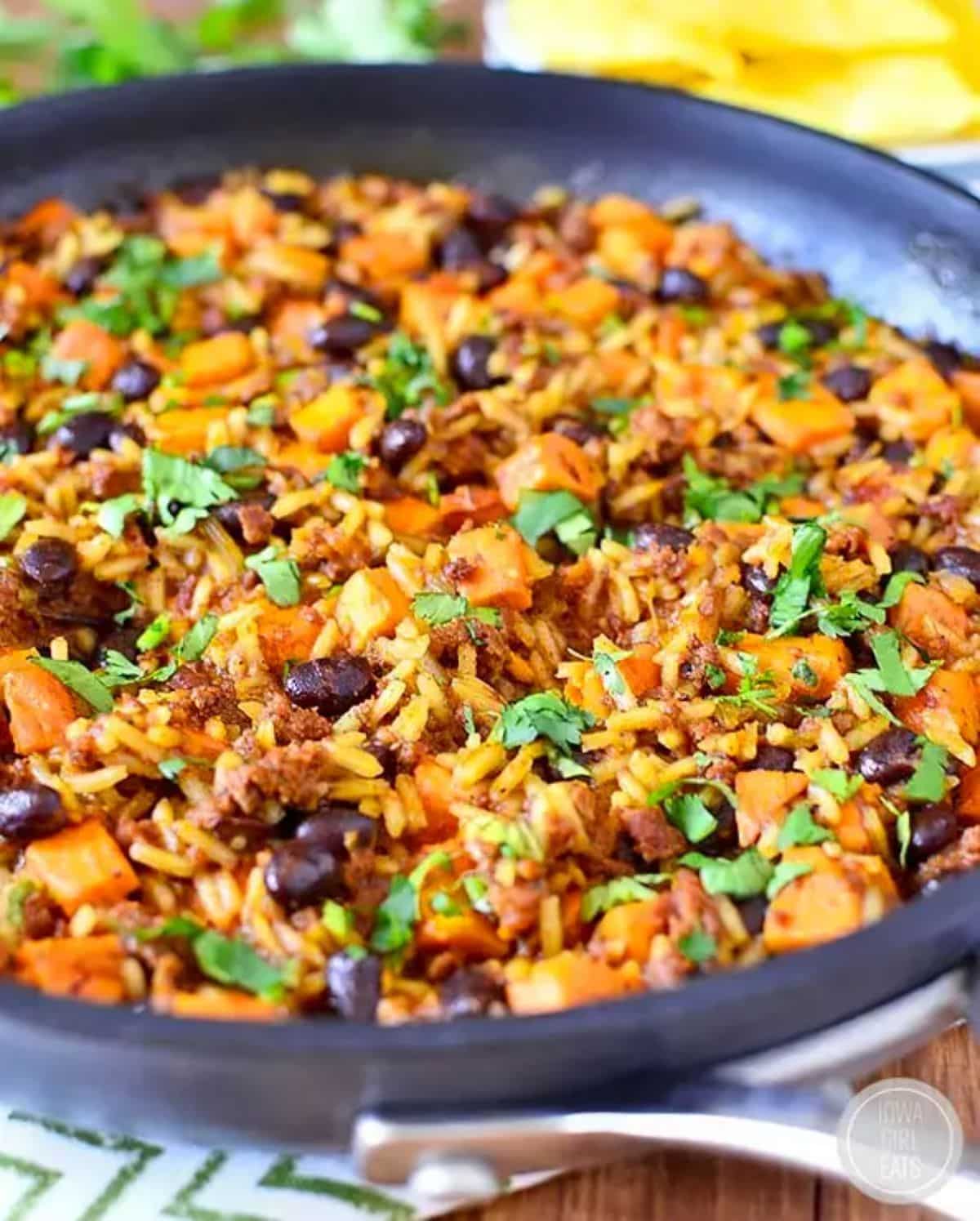 Chorizo, Sweet Potato, and Black Bean Rice on a black skillet.