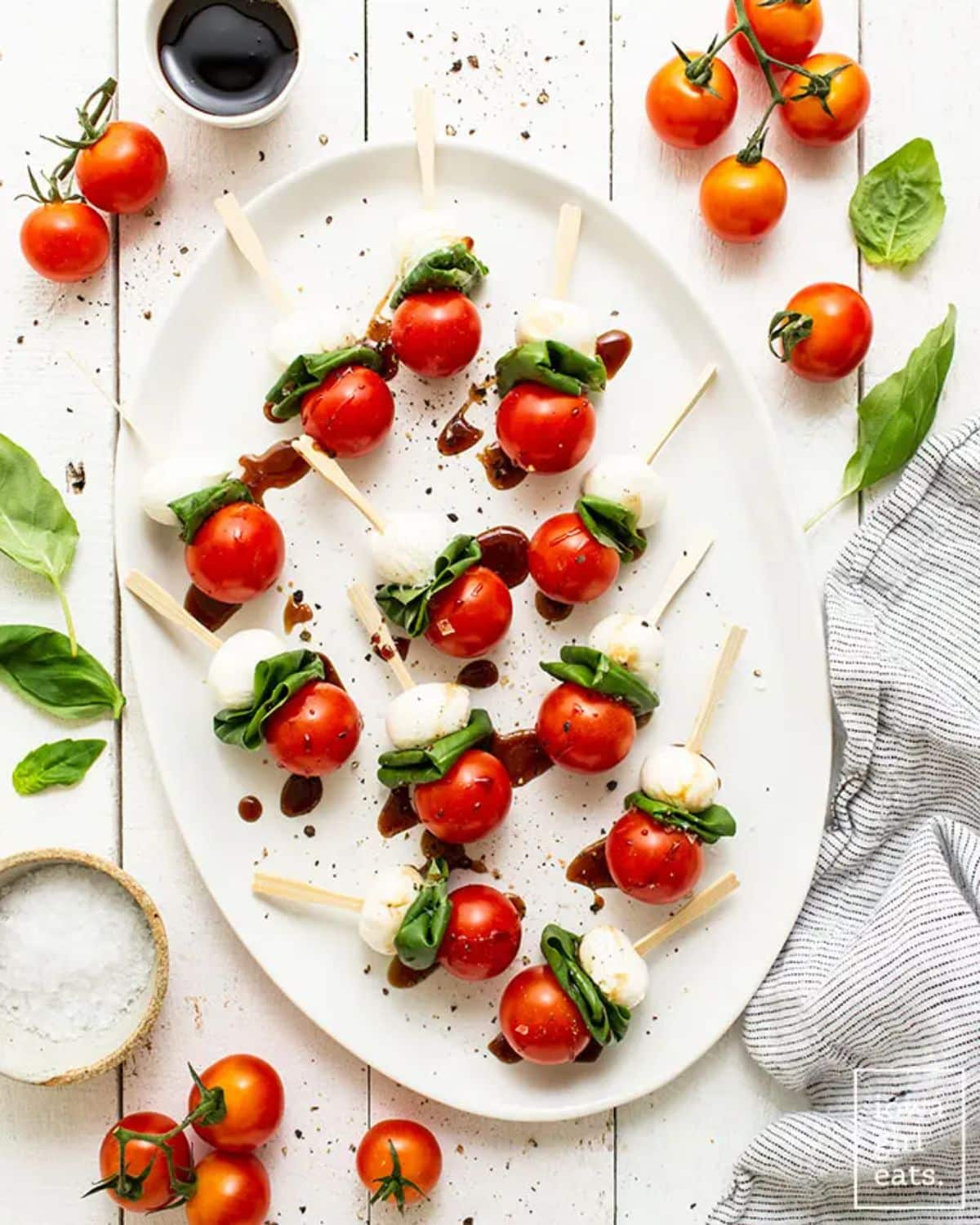 Caprese Skewers with Balsamic Drizzle on a white tray.