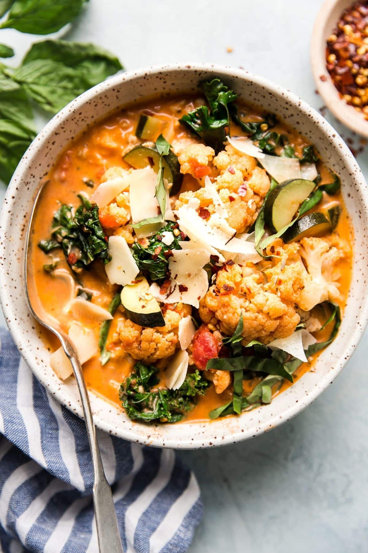 Creamy Tomato Soup with Chicken and Vegetables in a bowl with a spoon.