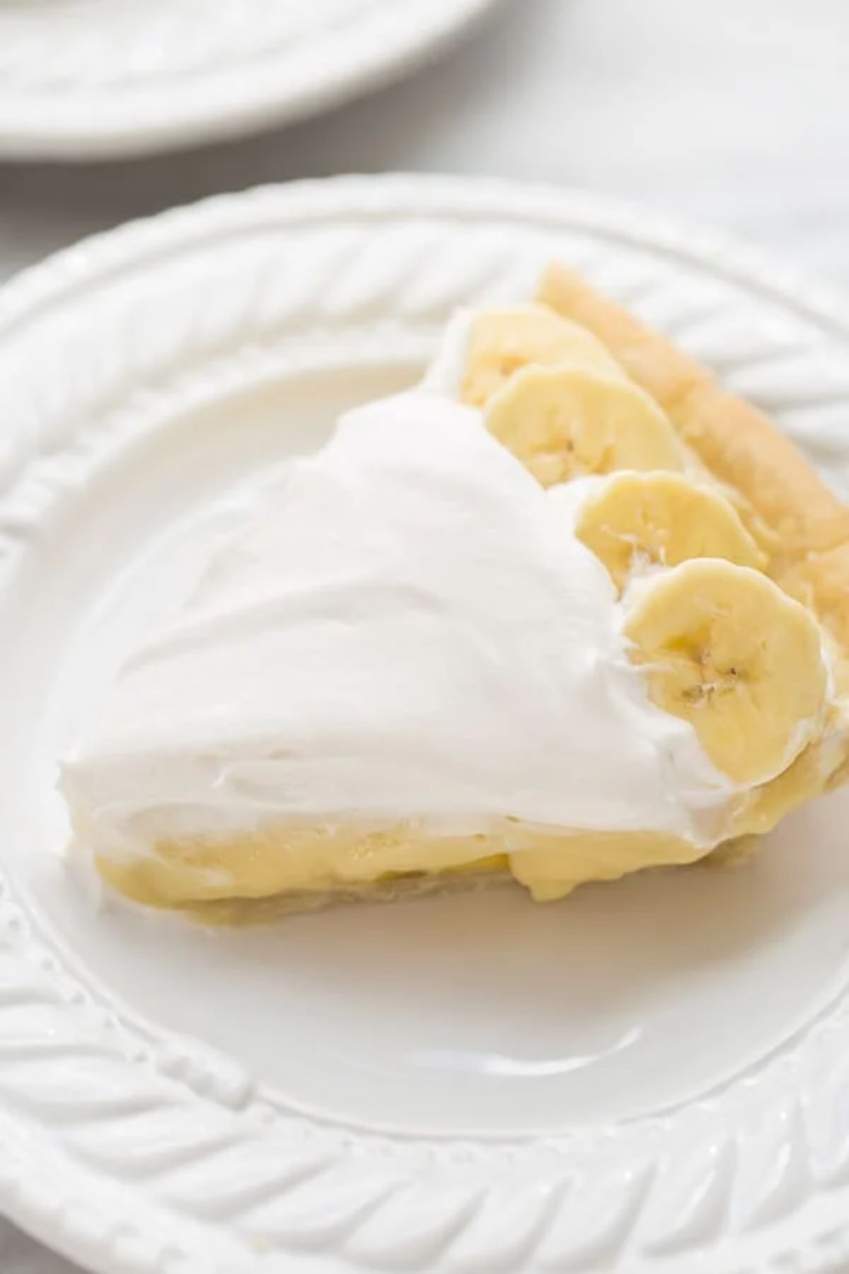 A piece of Dairy-Free Banana Cream Pie on a white plate.