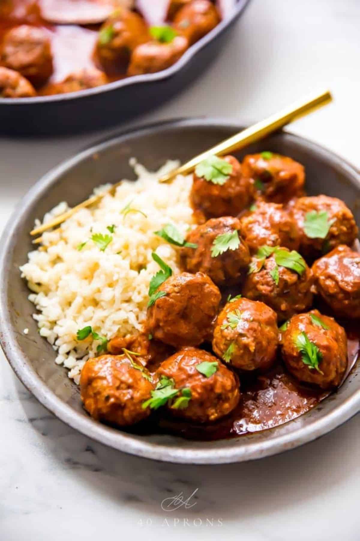 Indian Meatballs with Creamy Sauce and rice on a gray plate.