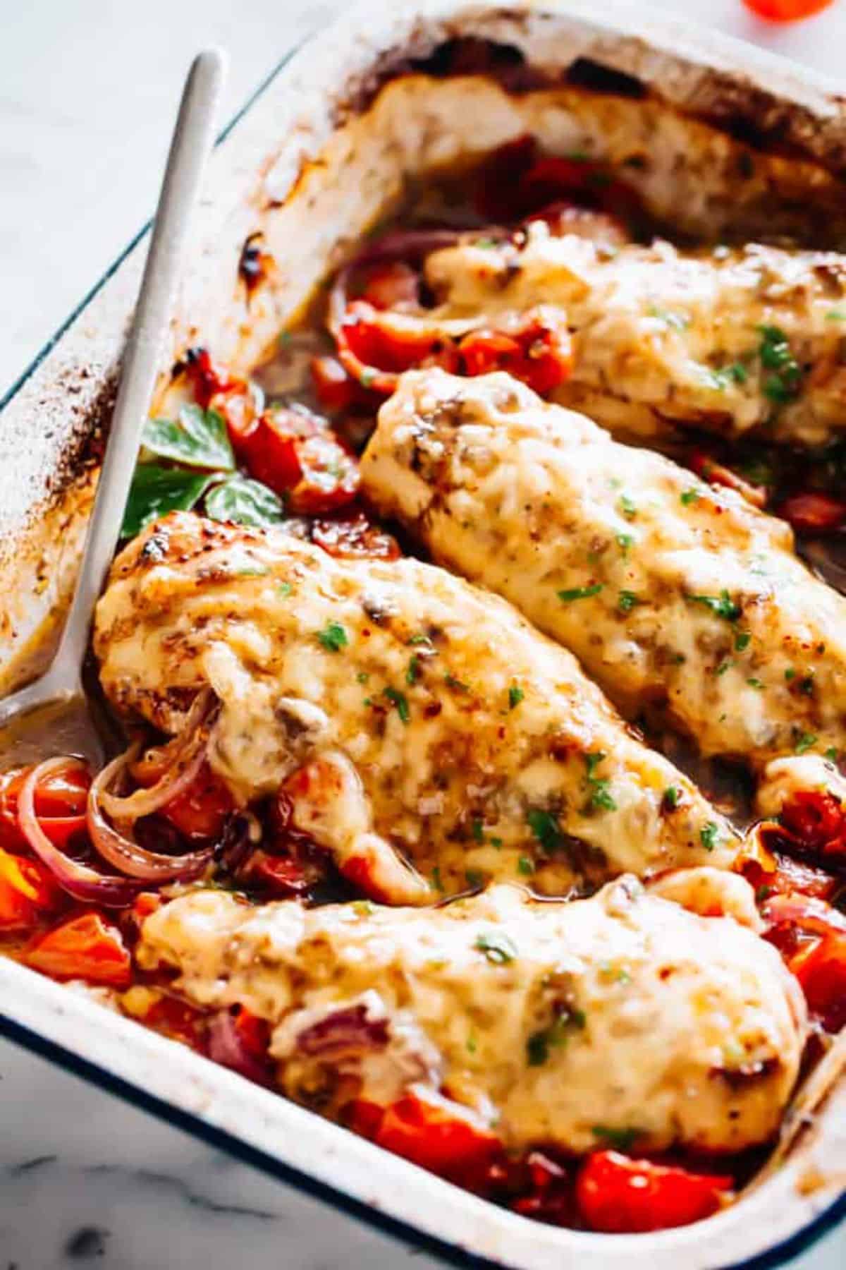 Caprese Balsamic Baked Chicken Breasts with a spoon in a casserole.