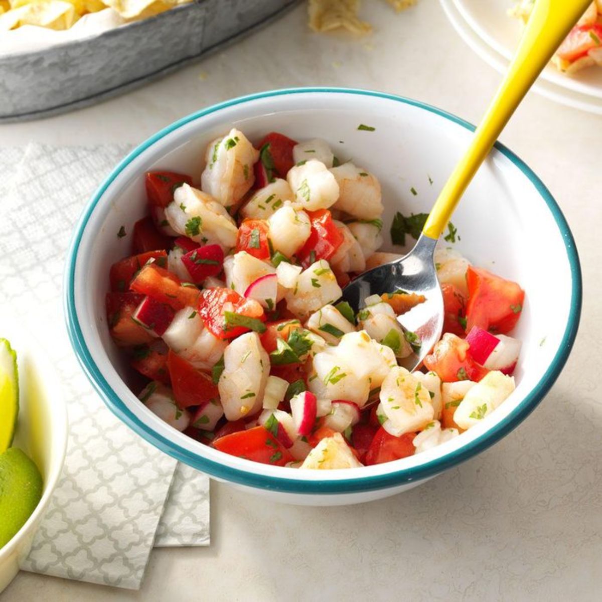 Spicy Shrimp Salsa in a white-blue bowl with a spoon.