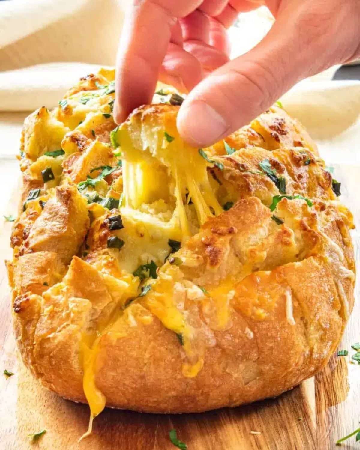 Gluten-Free Cheese Pull-Apart Bread picked by a hand.