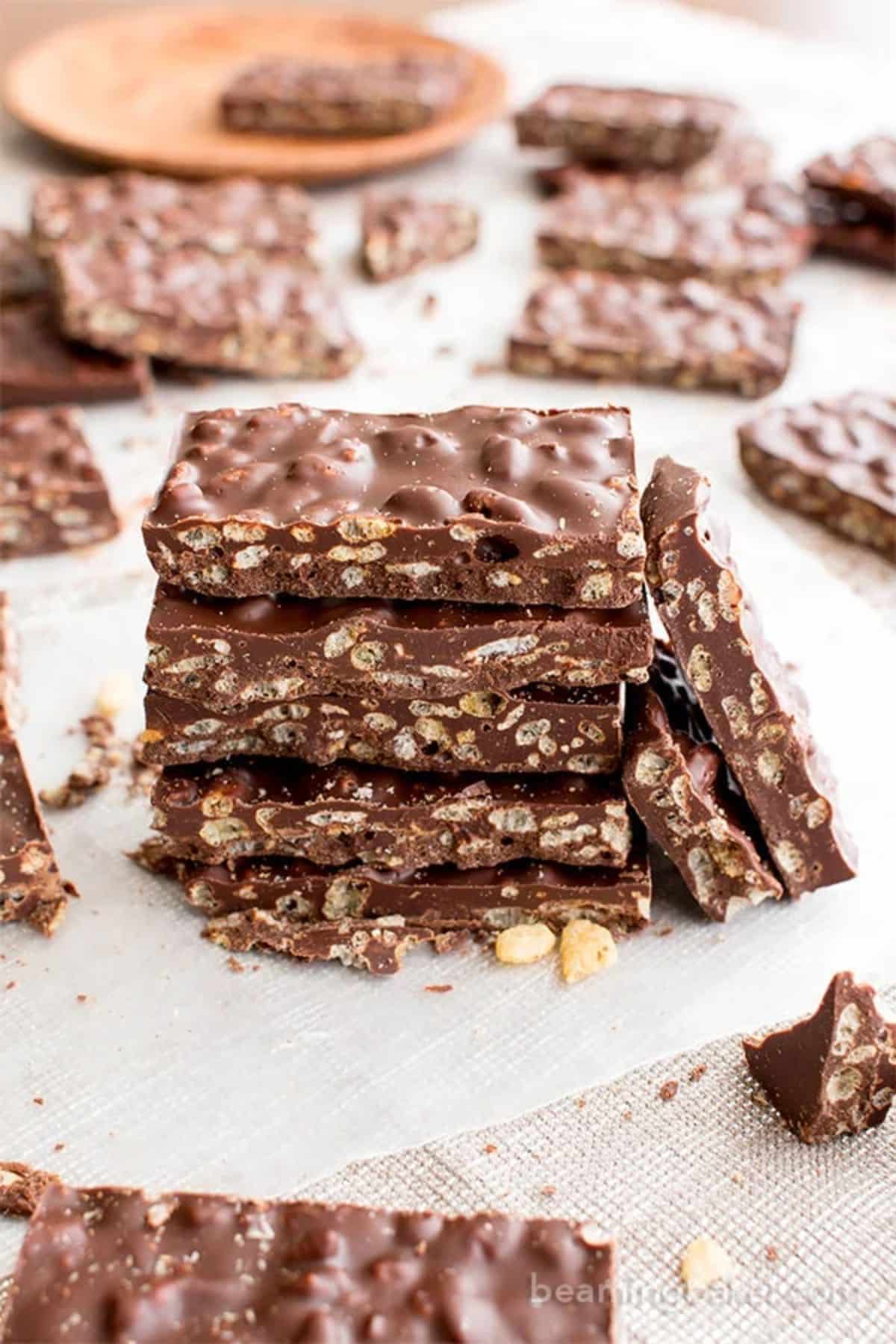 A pile of Homemade Crunch Bars on a parchment paper.