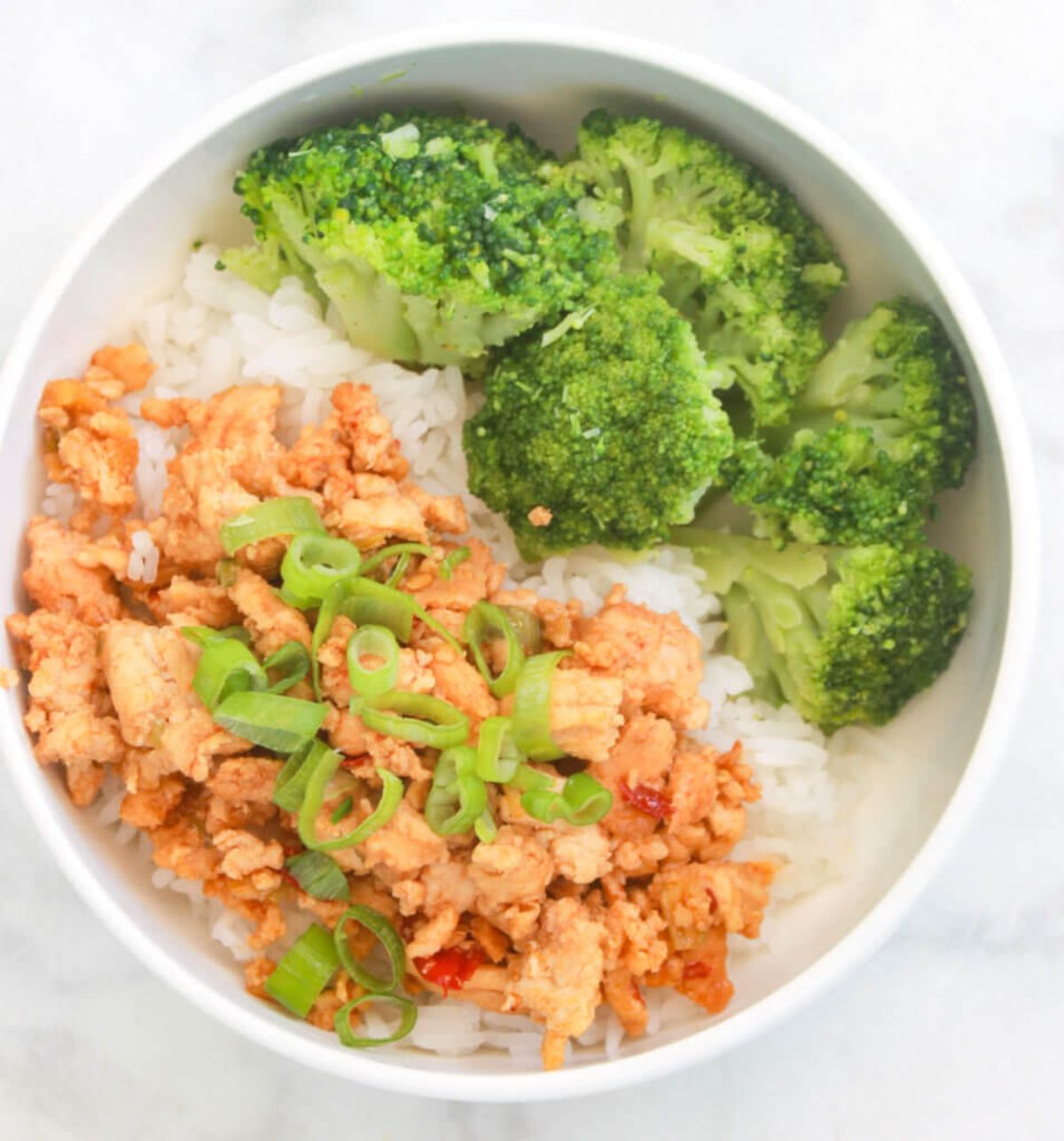 Asian Ground Chicken with broccoli and rice in a white bowl.