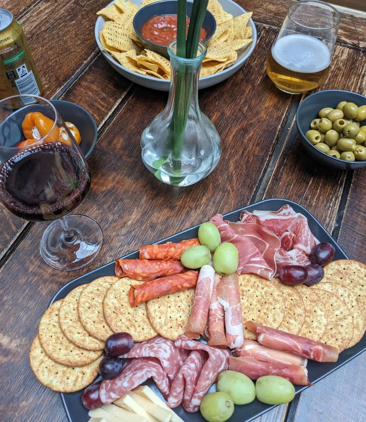 Gluten-Free Cured Meats with crackers and fruits on a gray tray.
