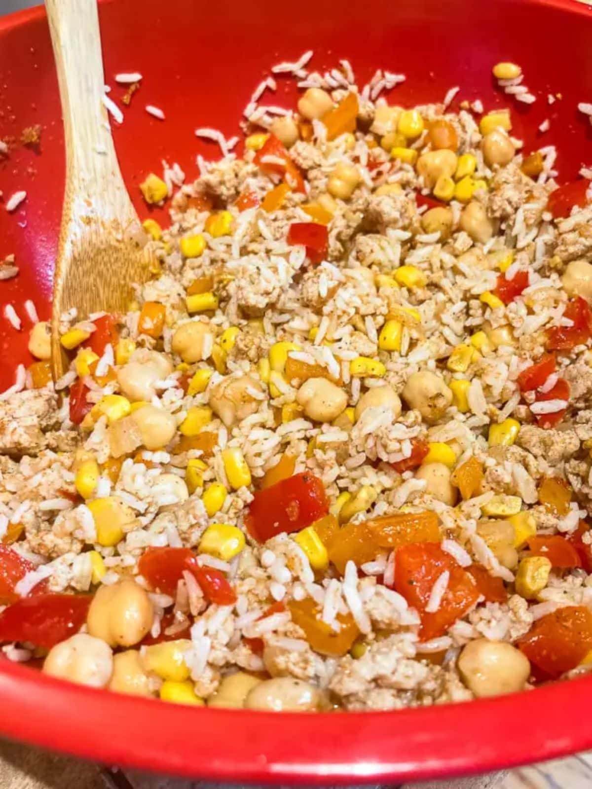 Taco Rice with a wooden spoon in a red bowl.