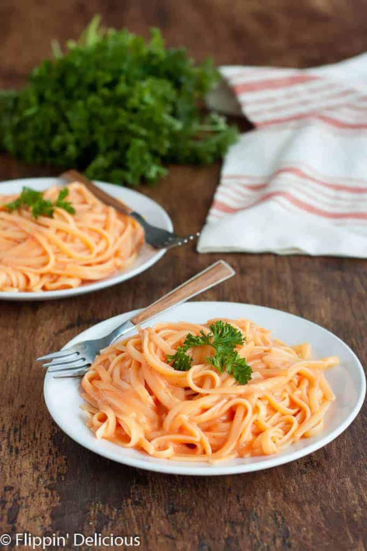 Vegan Roasted Red Pepper Alfredo on a white plate with a fork.