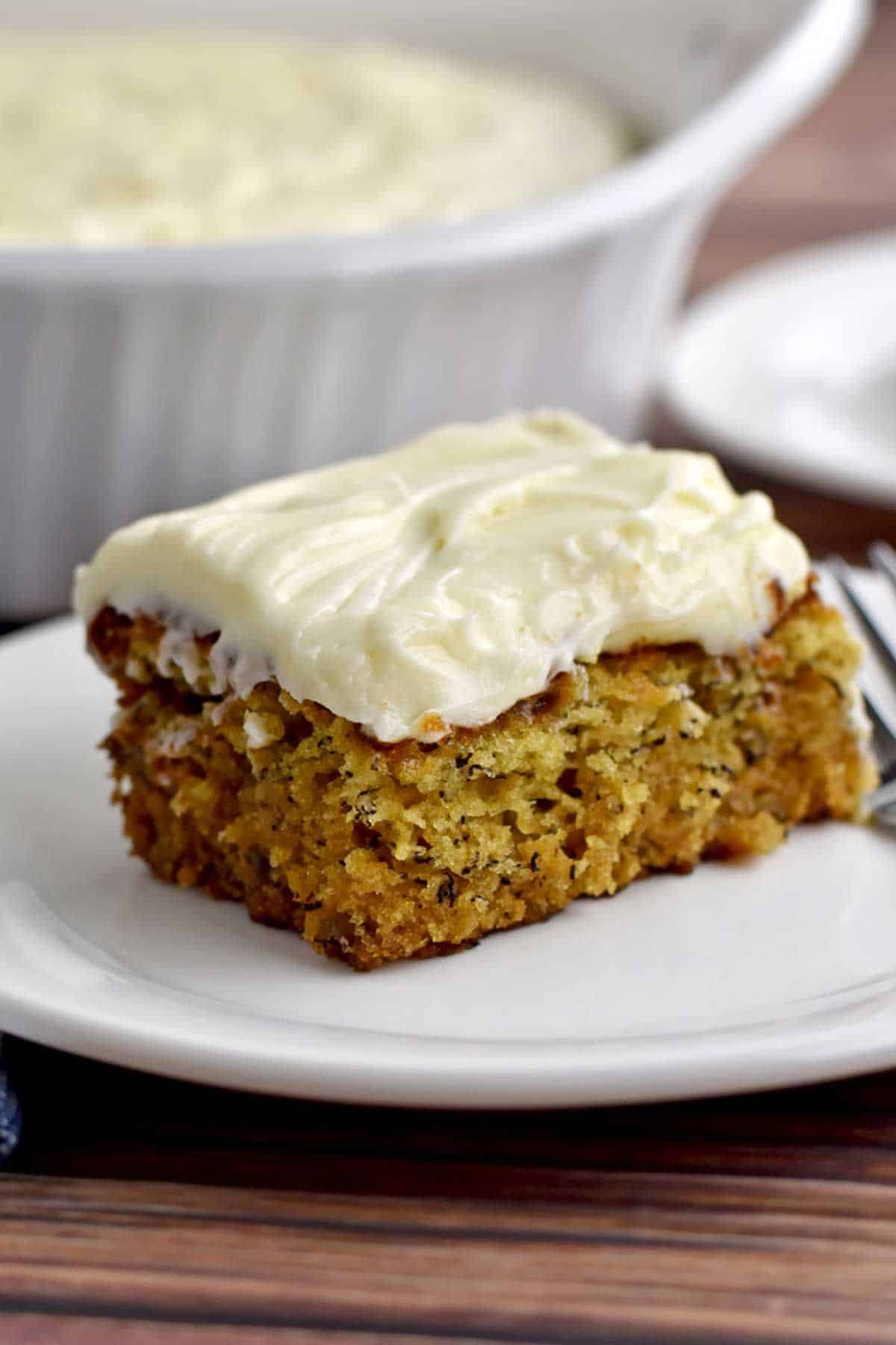 A piece of Gluten-Free Banana Cake With Cream Cheese Frosting on a white plate.