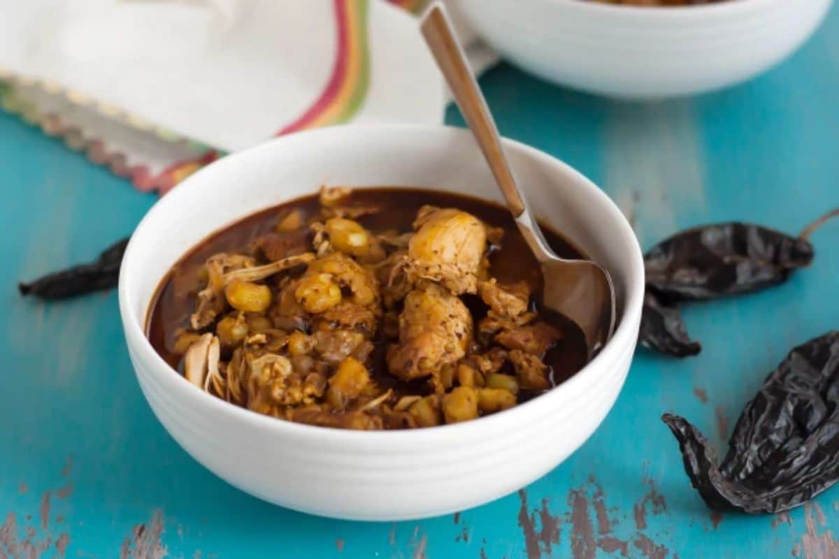 Delicious gluten-free Chicken Posole in a white bowl with a spoon.