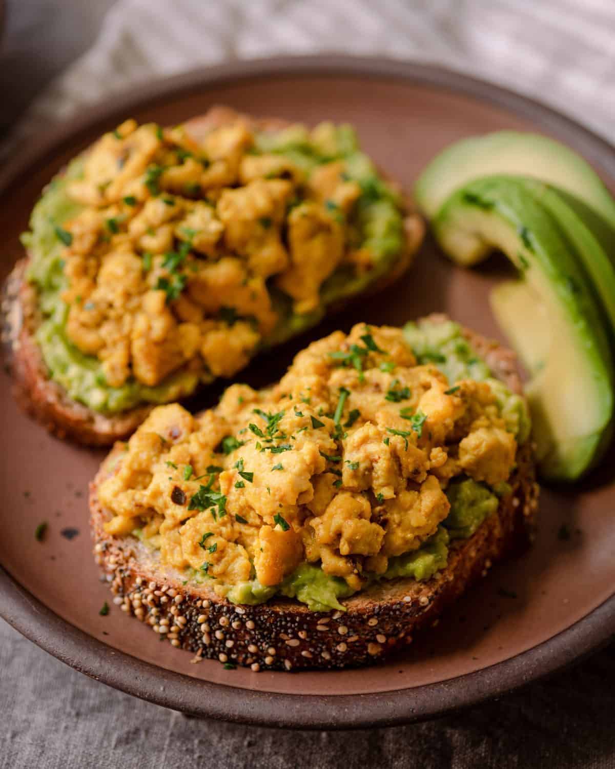 Tofu Scramble on slices of bread on a brown plate.