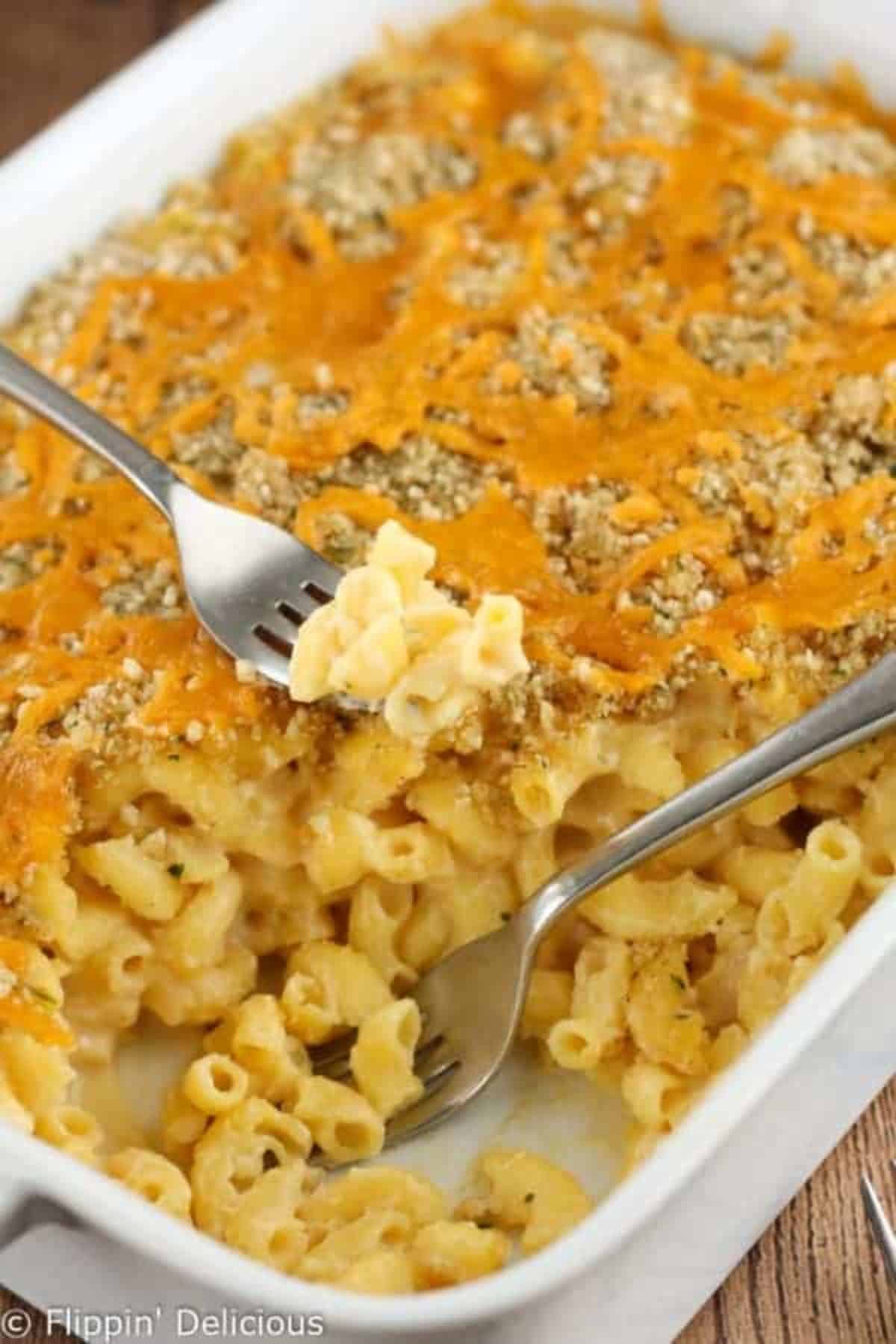 Baked Gluten-Free Mac and Cheese in a white casserole with two forks.