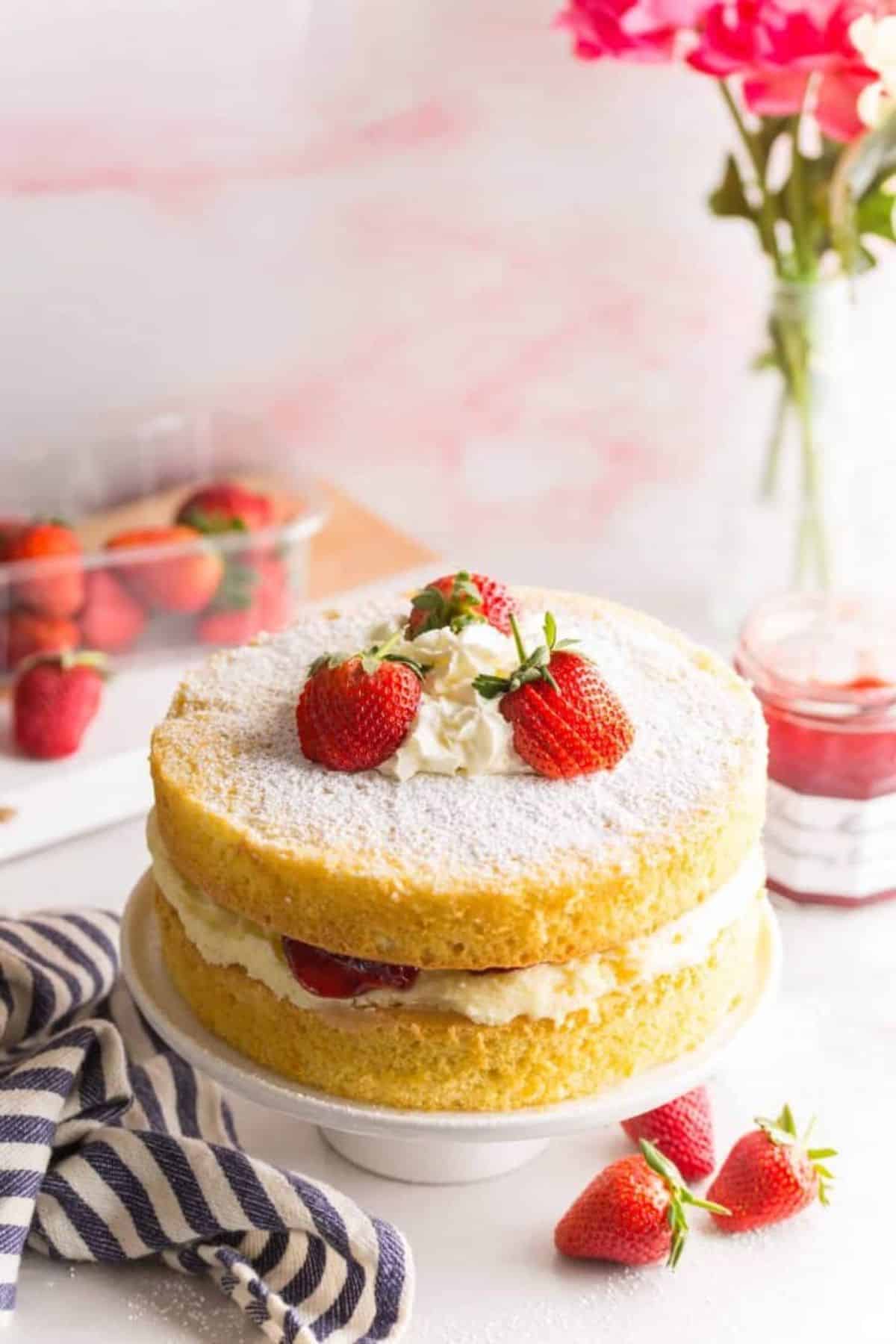 A delicious Gluten-Free Victoria Sponge Cake on a cake tray.