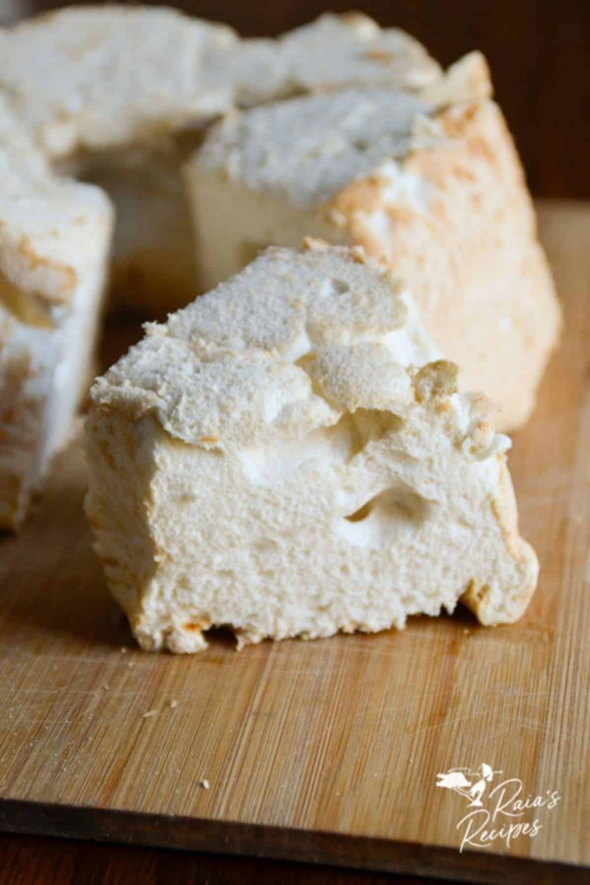 Sliced Cassava Flour Angel Food Cake on a wooden cutting board.