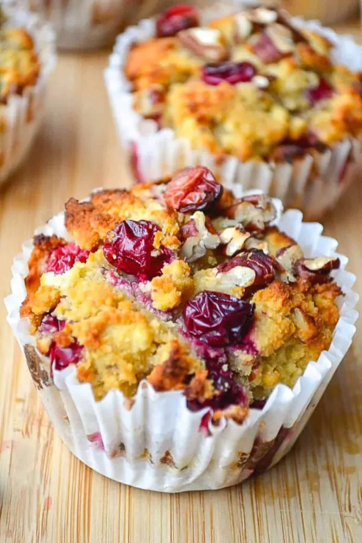 Delicious Gluten-Free Cranberry, Orange, and Pecan Muffins on a wooden table.