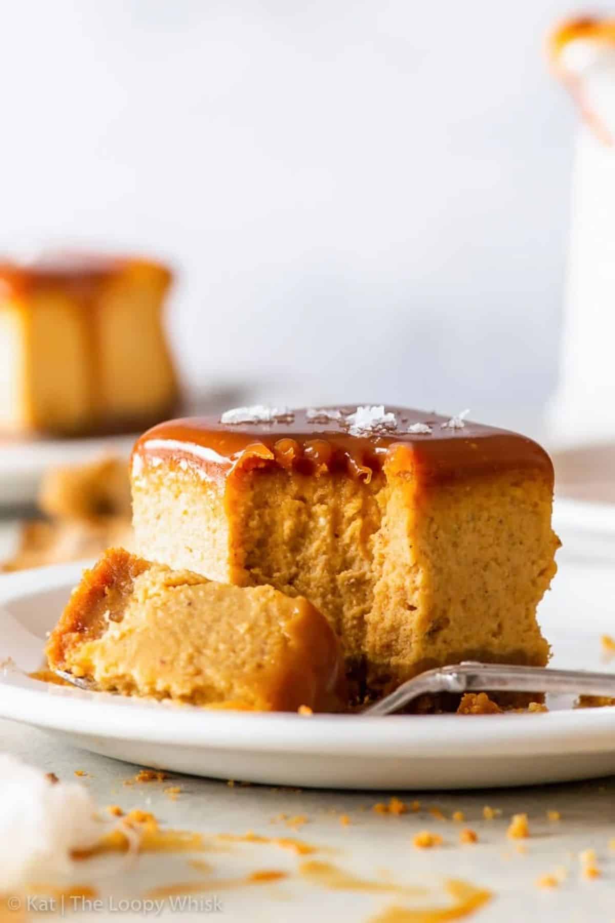 Salted Caramel Pumpkin Cheesecake Bar on a white plate with a fork.