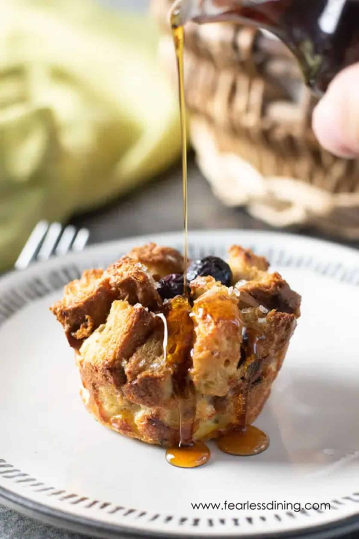 Gluten-Free Blueberry French Toast Muffin poured with syrup on a plate.