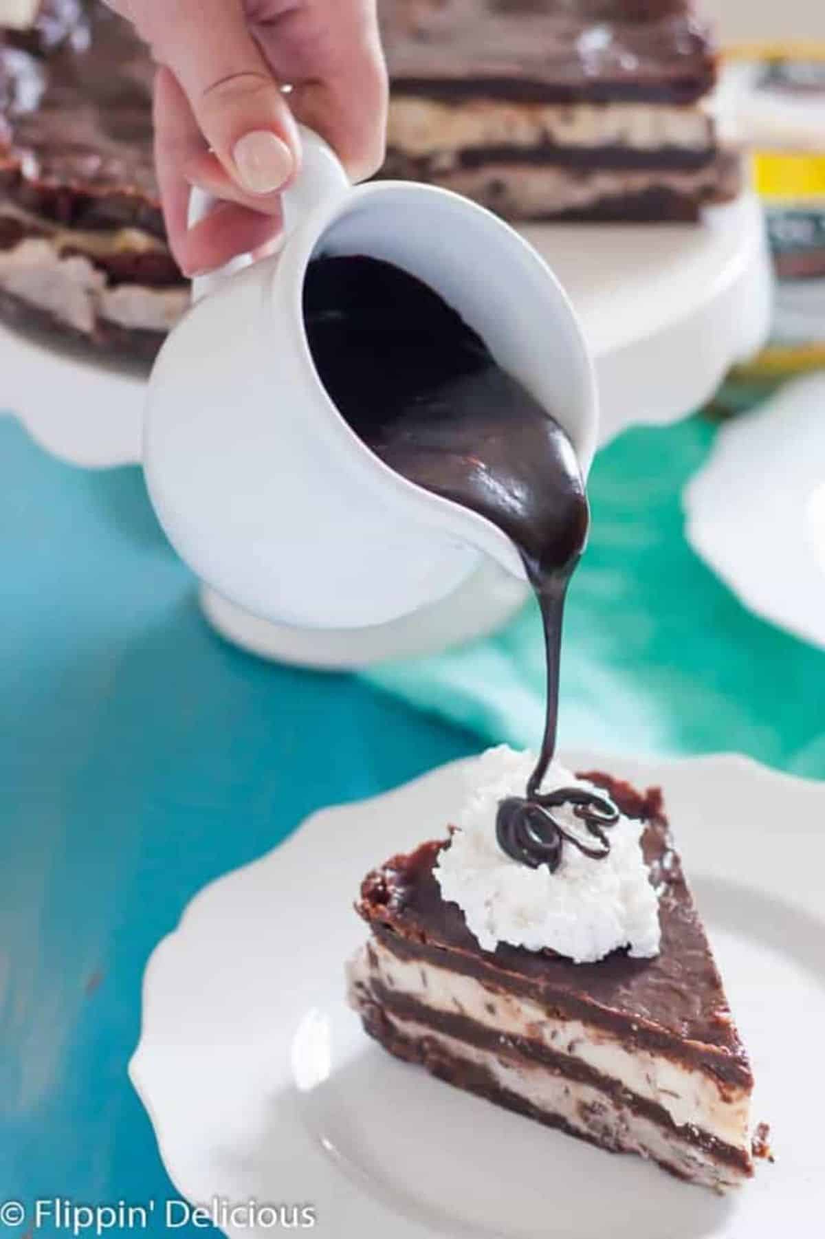 Dairy-Free Hot Fudge Sauce poured on a piece of cake.