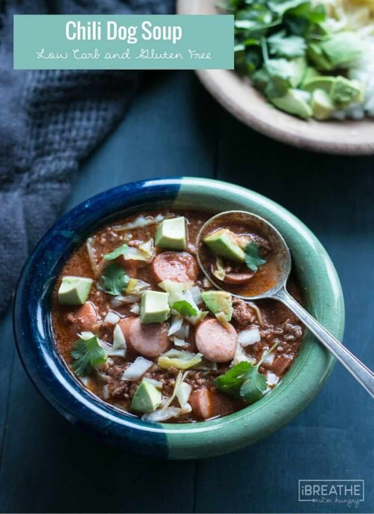 Delicious Chili Dog Soup in a blue bowl with a spoon.