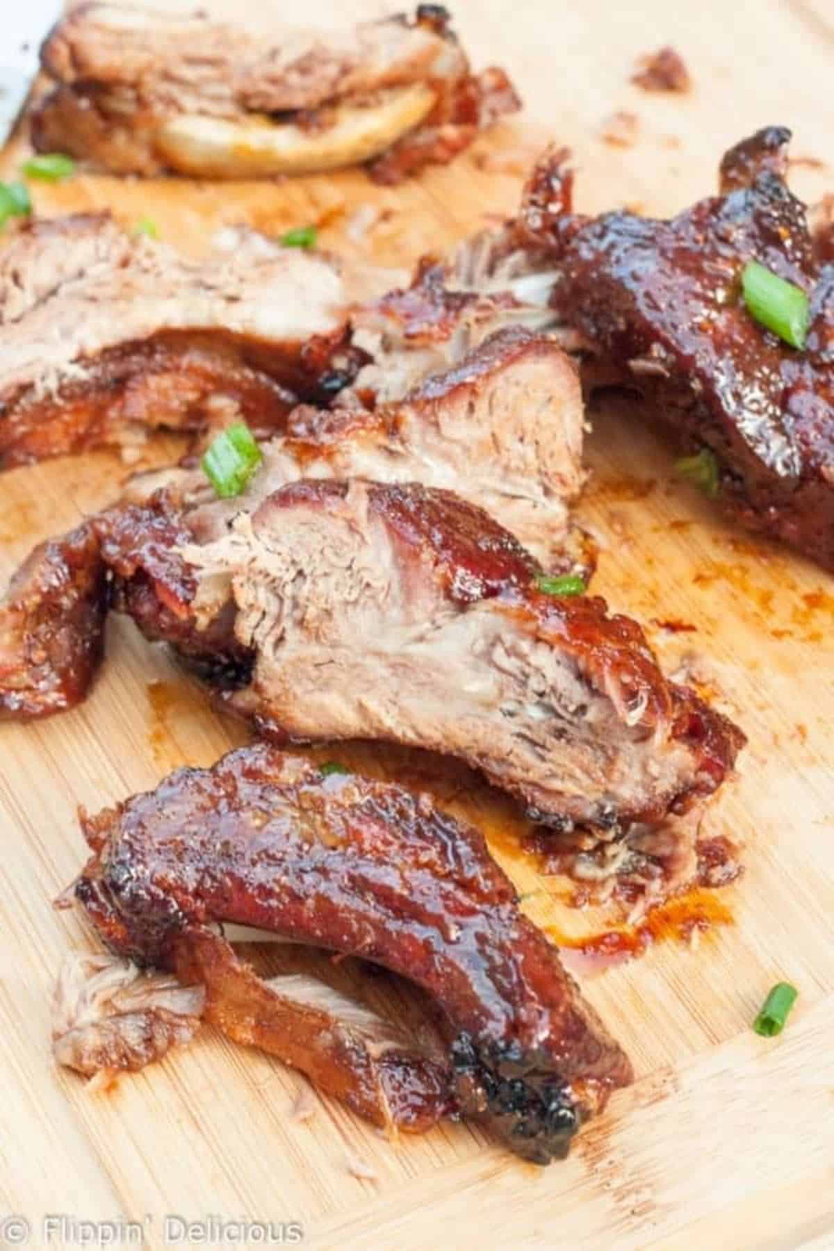 Juicy Gluten-Free Sticky Asian Ribs on a wooden tray.