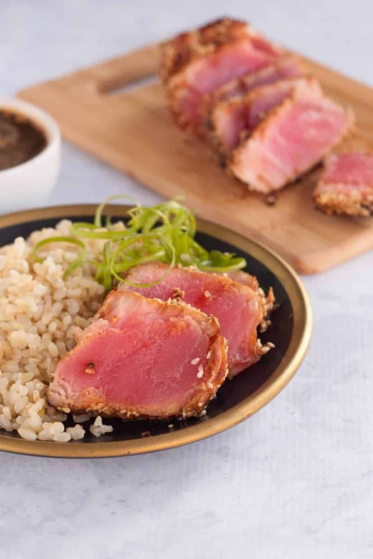 Seared Ahi Tuna steaks with rice on a plate.