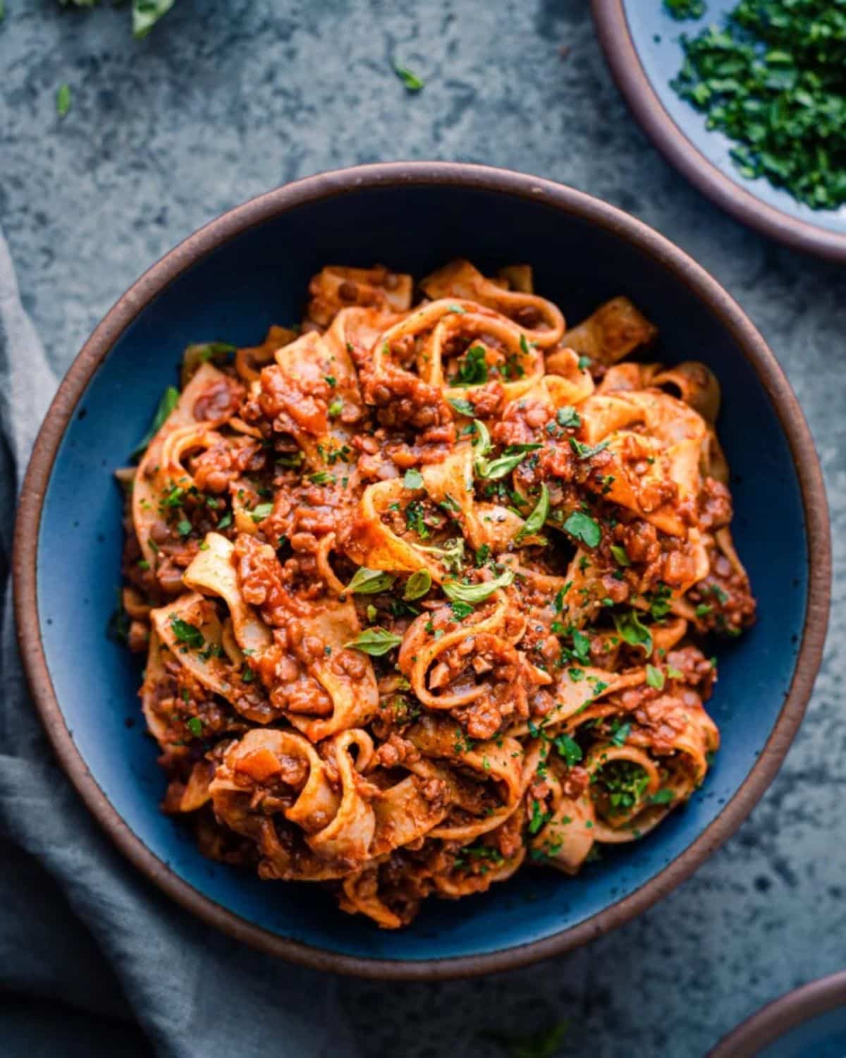 DElicious 10-Ingredient Lentil Bolognese in a blue bowl.