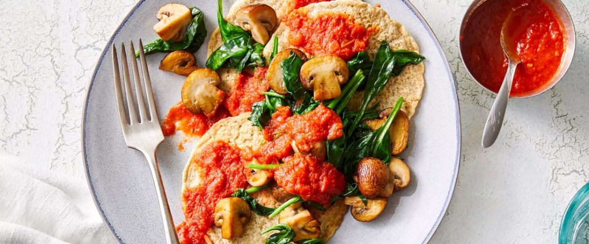 Savory Pancakes with Sautéed Mushrooms and Spinach on a white plate.