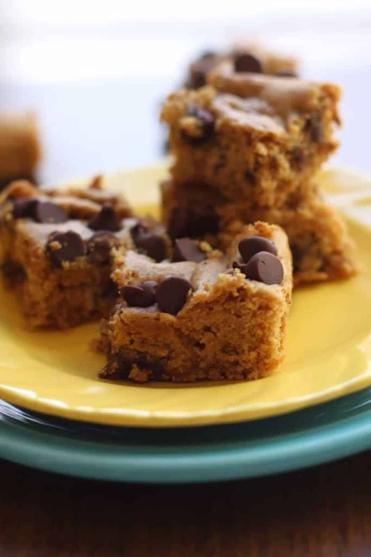 DElicious Gluten-Free Blondies with Chocolate Chips on a yellow plate.