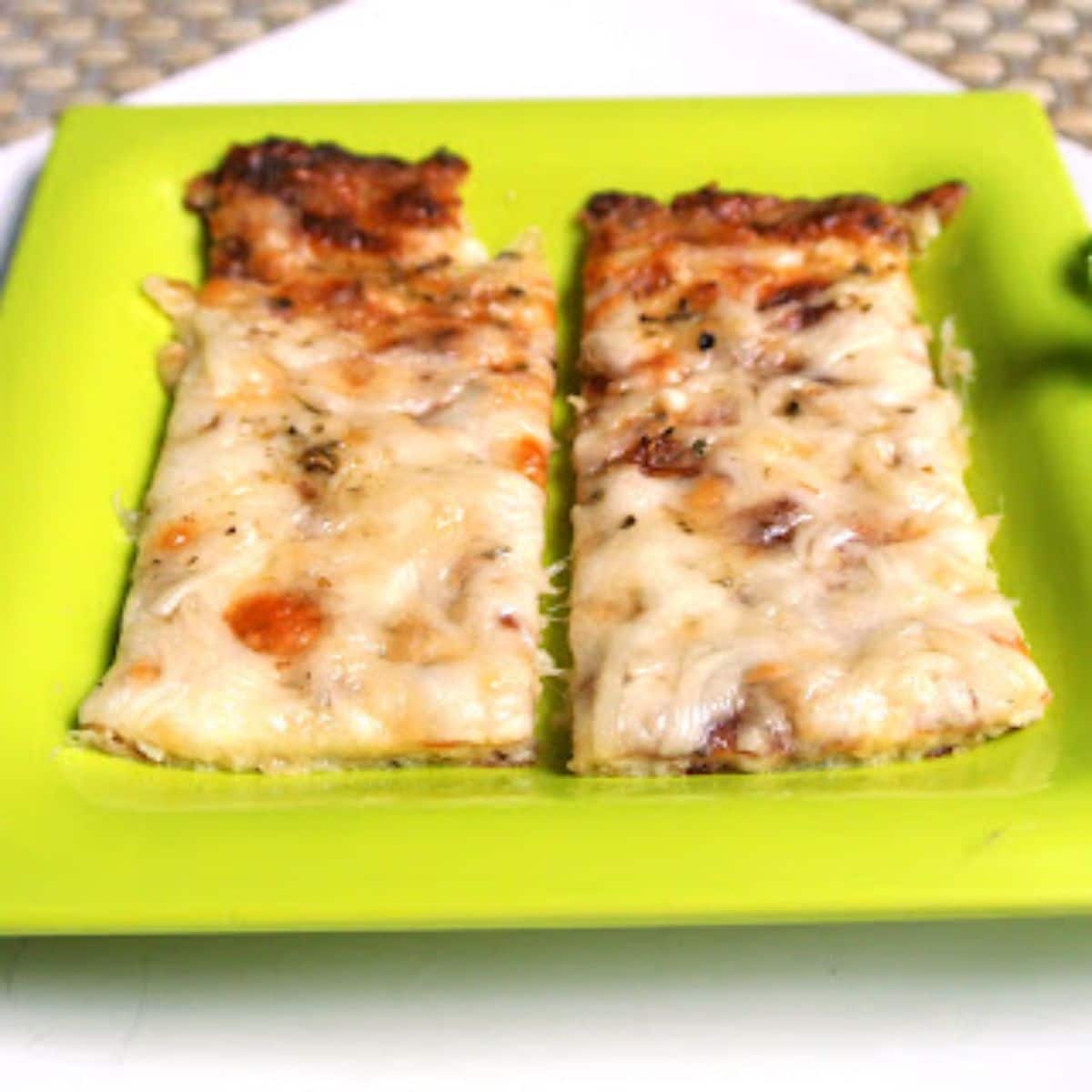 Cheesy Garlic Cauliflower Bread Sticks on a green plate.