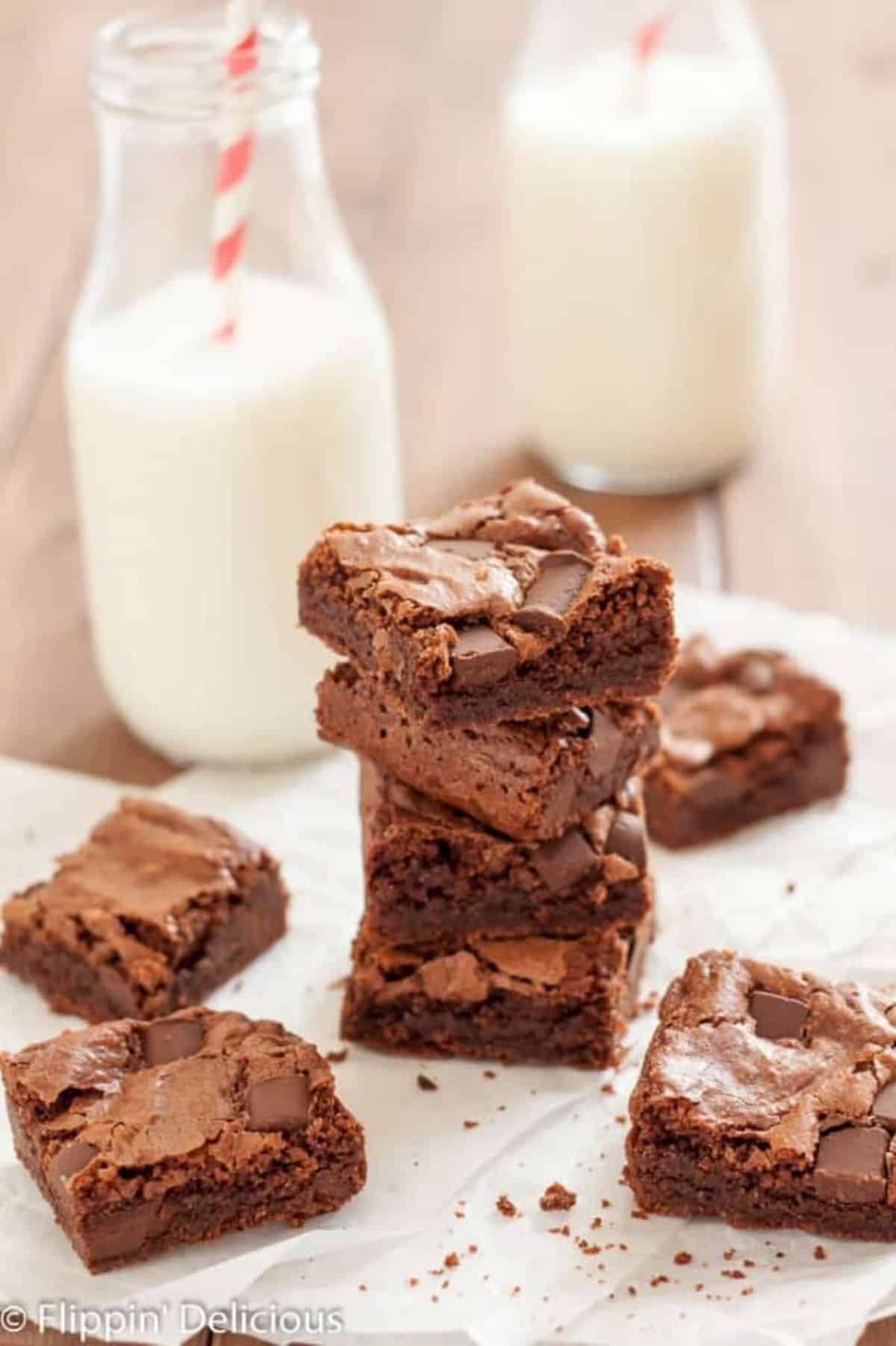 Delicious Almond Flour Brownies with jars of milk on a wooden table.