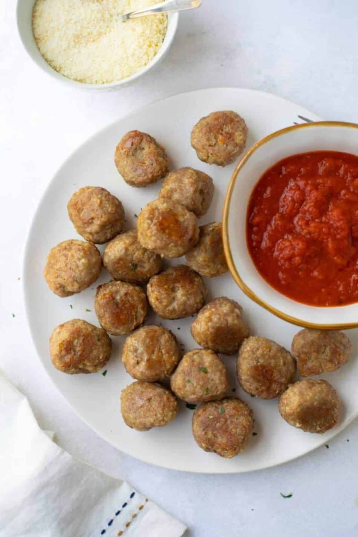Gluten-free Turkey Meatballs with a bowl of dip on a white plate.